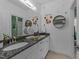 Dual sink vanity in a bright bathroom with modern fixtures and decorative wall art at 1037 Lila Ln, Raleigh, NC 27614