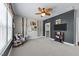 Spacious bedroom with cozy seating, cowhide accents, a ceiling fan, and a mounted flat screen television at 1037 Lila Ln, Raleigh, NC 27614