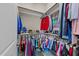 Walk-in closet with rods and shelves filled with colorful clothing and accessories at 1037 Lila Ln, Raleigh, NC 27614