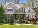 Charming home featuring stone accents, complemented by a landscaped front yard and covered entry at 1037 Lila Ln, Raleigh, NC 27614