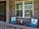Inviting front porch with stone facade, rocking chairs, and leafy decorative pillows at 1037 Lila Ln, Raleigh, NC 27614