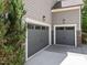 Attached two car garage featuring modern doors and exterior lighting at 1037 Lila Ln, Raleigh, NC 27614