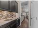 Kitchen features dark cabinetry, wine fridge, sink, and tiled backsplash, perfect for entertaining and everyday use at 1037 Lila Ln, Raleigh, NC 27614