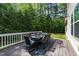 Outdoor dining area on wooden deck surrounded by lush greenery at 1037 Lila Ln, Raleigh, NC 27614