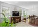Bright living room with hardwood floors, large windows, modern decor, and view into the dining area at 1041 Cotulla Dr, Morrisville, NC 27560