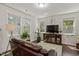 Bright living room with large windows, hardwood floors, modern decor, and a comfortable sofa at 1041 Cotulla Dr, Morrisville, NC 27560