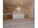 Spacious living room featuring neutral carpet, vaulted ceilings, and an open concept kitchen with wood cabinets at 10461 Dapping Dr, Raleigh, NC 27614