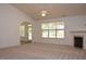 Large living room featuring neutral carpeting, fireplace, and backyard access at 10461 Dapping Dr, Raleigh, NC 27614