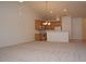 Open-concept living room with neutral carpet and wood-cabinet kitchen with modern appliances at 10461 Dapping Dr, Raleigh, NC 27614