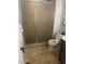 Bright bathroom with a glass-enclosed shower and tile flooring, toilet, vanity with framed mirror, and decor at 10505 Winding Wood Trail Trl, Raleigh, NC 27613