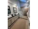 Bathroom featuring double sink vanity, glass block shower partition, and a tiled shower at 10505 Winding Wood Trail Trl, Raleigh, NC 27613