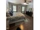 Comfortable primary bedroom features hardwood floors, a ceiling fan, and natural lighting at 10505 Winding Wood Trail Trl, Raleigh, NC 27613