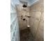 Tiled shower features mosaic tile floors, glass block partition, and modern shower head fixtures at 10505 Winding Wood Trail Trl, Raleigh, NC 27613
