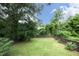 The expansive backyard has a lush lawn and is framed by trees, creating a natural and peaceful retreat at 106 Eugene St, Carrboro, NC 27510
