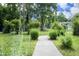 View of a walkway leading to a charming home through a lush, green front yard at 106 Eugene St, Carrboro, NC 27510
