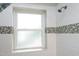 Close-up of a newly tiled shower with mosaic details and frosted window at 106 Eugene St, Carrboro, NC 27510