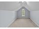 A finished attic space with neutral walls, carpeted floor, and natural light from a window at 106 Wolverton Dr, Clayton, NC 27527