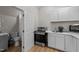 A kitchenette with white cabinets, an oven, a microwave, and access to a bathroom at 106 Wolverton Dr, Clayton, NC 27527