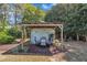 Cozy outdoor dining area featuring a charming pergola shaded by lush greenery, perfect for relaxing and entertaining guests at 1112 Turner Farms Rd, Garner, NC 27529