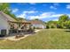 Expansive backyard featuring a covered patio, lush green lawn, and beautiful landscaping against a backdrop of a bright blue sky at 1112 Turner Farms Rd, Garner, NC 27529