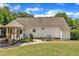 View of the side of a home with a covered patio, and garden area in the backyard, surrounded by green grass and trees at 1112 Turner Farms Rd, Garner, NC 27529