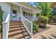 Inviting front porch with brick steps and white railings, surrounded by green bushes at 1112 Turner Farms Rd, Garner, NC 27529