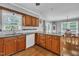Traditional kitchen features wood cabinets, marble backsplash, and stainless dishwasher overlooking dining area at 1112 Turner Farms Rd, Garner, NC 27529