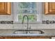 Close up of the kitchen sink and marble backsplash illuminated by natural light from the window at 1112 Turner Farms Rd, Garner, NC 27529
