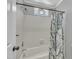 Shower and tub combination featuring a white tile surround and decorative shower curtain at 1112 Turner Farms Rd, Garner, NC 27529