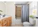 Well-lit bathroom with neutral tile, tub-shower, framed mirror, and single sink vanity at 117 Idlewild Ave, Raleigh, NC 27601