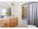 Bathroom with double sinks, a framed mirror, wood cabinets, cream walls, and a tub-shower combo at 117 Idlewild Ave, Raleigh, NC 27601