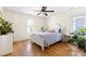 Bright bedroom featuring a white bed frame, hardwood floors, natural light from windows, and plant decor at 117 Idlewild Ave, Raleigh, NC 27601