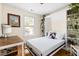 Bright bedroom features a Murphy bed pulled down, built-in shelves with decor, and a wood desk by the window at 117 Idlewild Ave, Raleigh, NC 27601