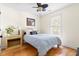 Cozy bedroom featuring a ceiling fan, wood floors, a bedside table, and a comfortable queen-size bed at 117 Idlewild Ave, Raleigh, NC 27601