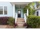 Inviting front porch with lush greenery and a decorative front door at 117 Idlewild Ave, Raleigh, NC 27601