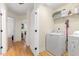 Bright laundry room with wooden floors, washer, dryer, and shelf storage at 117 Idlewild Ave, Raleigh, NC 27601