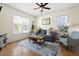 Cozy living room featuring natural light, a plush sofa, stylish rug, and a ceiling fan at 117 Idlewild Ave, Raleigh, NC 27601