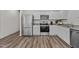 Modern kitchen with stainless steel appliances, granite countertops, and stylish wood flooring at 117 N Chubb Rdg, Wilson's Mills, NC 27520