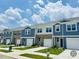 New townhomes with eye-catching facades, enhanced by professional landscaping and prominent signage, creating an inviting neighborhood vibe at 119 N Chubb Rdg, Wilson's Mills, NC 27520