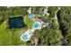 Aerial view of community amenities featuring a pool, tennis courts, lake and clubhouse surrounded by lush trees at 120 Avent Pines Ln, Holly Springs, NC 27540