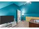 Bright bedroom featuring blue walls, wood floors, and a television for relaxing entertainment at 120 Avent Pines Ln, Holly Springs, NC 27540