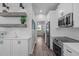 Stylish kitchen with wood floors, floating shelves, white cabinets, and stainless steel appliances at 120 Avent Pines Ln, Holly Springs, NC 27540