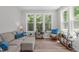 Bright living room with large windows, comfortable seating, and wood floors at 120 Avent Pines Ln, Holly Springs, NC 27540