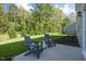 A relaxing backyard patio features comfortable Adirondack chairs surrounded by a lush green lawn at 1205 Pavo Path, Wendell, NC 27591