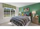 Stylish bedroom boasts window, green accent wall, and cozy bedding at 1205 Pavo Path, Wendell, NC 27591