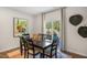 The dining room boasts a modern light fixture, large windows, and an elegant table with seating for six at 1205 Pavo Path, Wendell, NC 27591