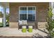 Cozy porch with a wooden bench and decorative stools against a brick facade for relaxation at 1205 Pavo Path, Wendell, NC 27591