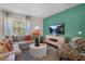 The living room features a plush sofa, patterned armchair, decorative coffee table, and large picture window at 1205 Pavo Path, Wendell, NC 27591