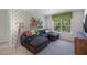 Cozy living room features patterned accent wall, grey sofa and oversized window at 1205 Pavo Path, Wendell, NC 27591