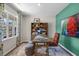 Well-lit home office with a large window, wooden desk, shelving unit, and comfortable seating at 1205 Pavo Path, Wendell, NC 27591
